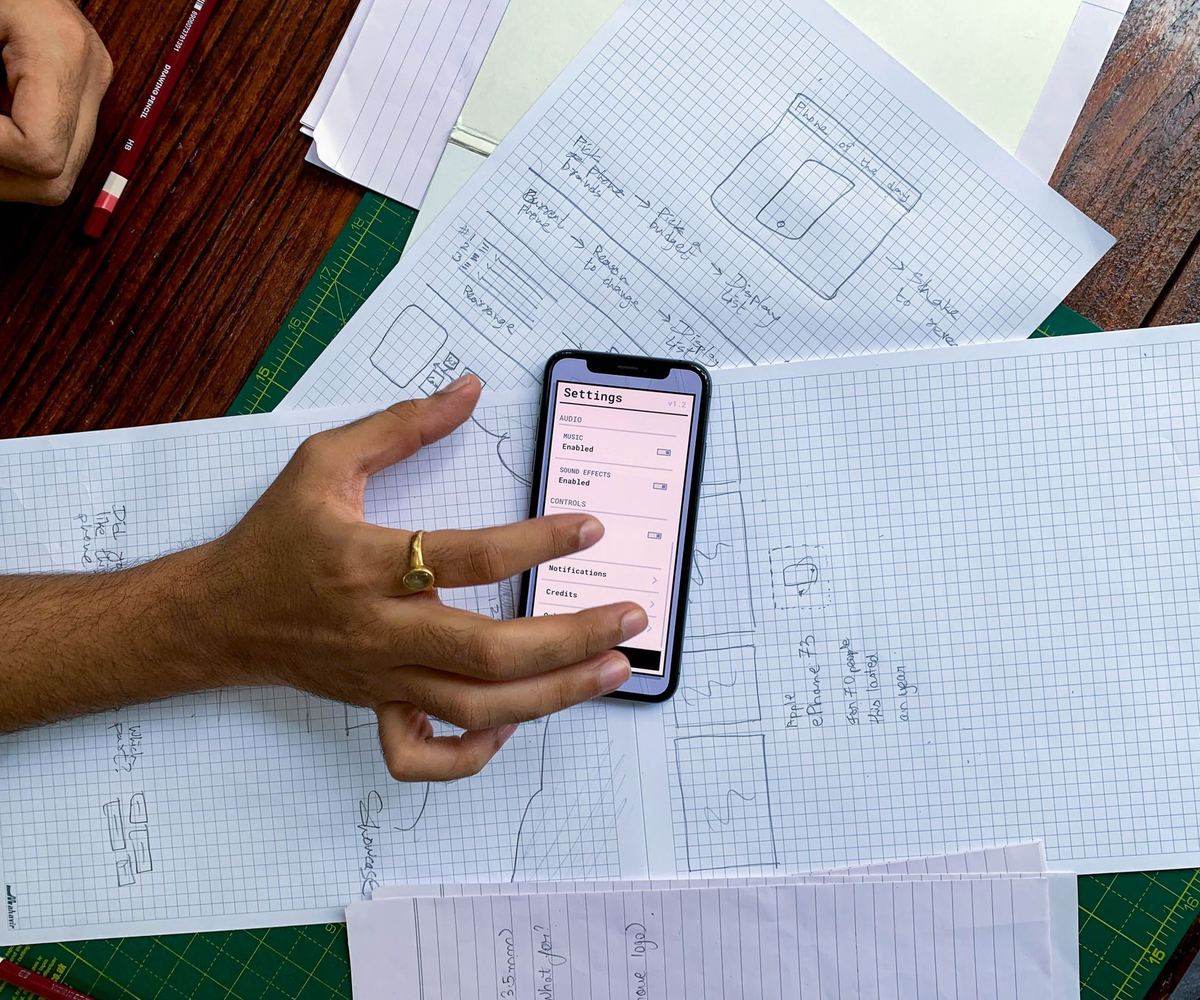 Eskiz kâğıtlarının üstünde tutulan bir telefon